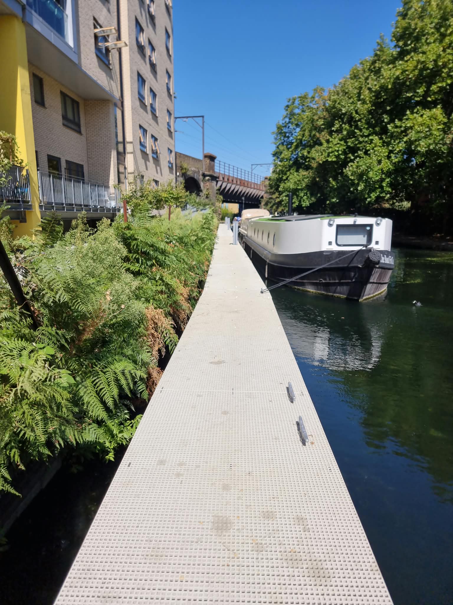 Elizabeth Wharf walkway with moored boat and planting